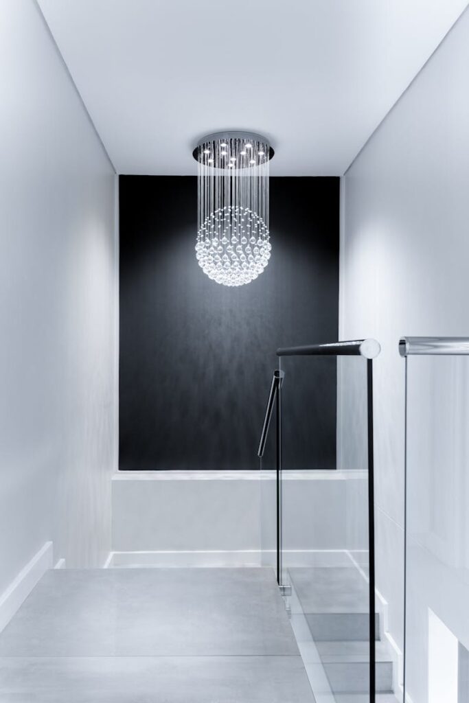 hohm-electrical-warrington-electricians Sleek contemporary hallway featuring a stunning glass chandelier and minimalist design.